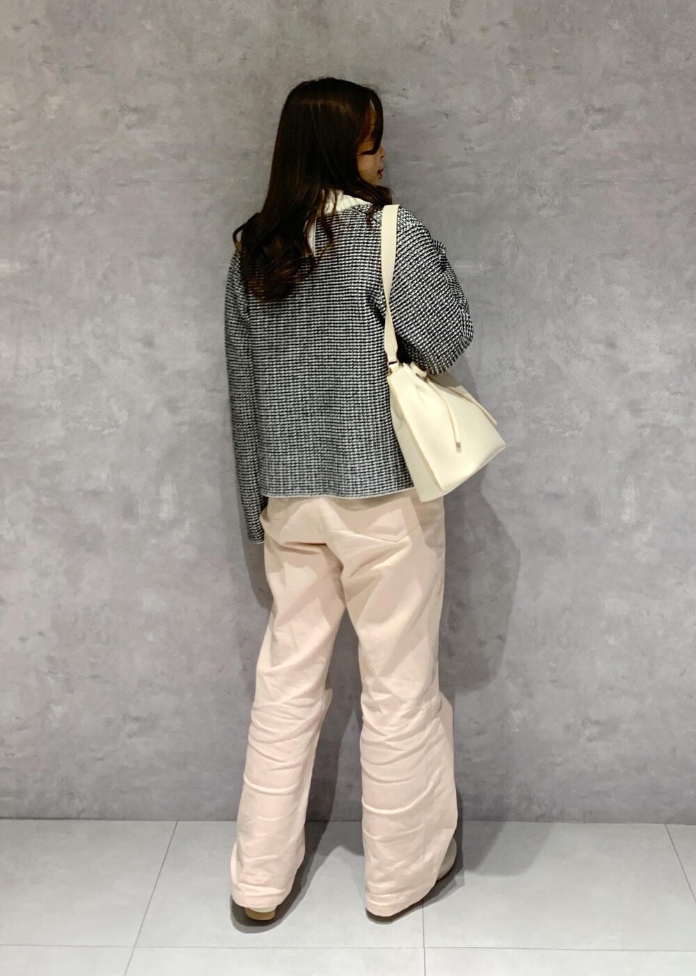 ピンク系のデニムパンツ、ホワイト系のハンドバッグ、ホワイト系のパンプスを着用したレディースの冬コーディネートの6枚目の写真