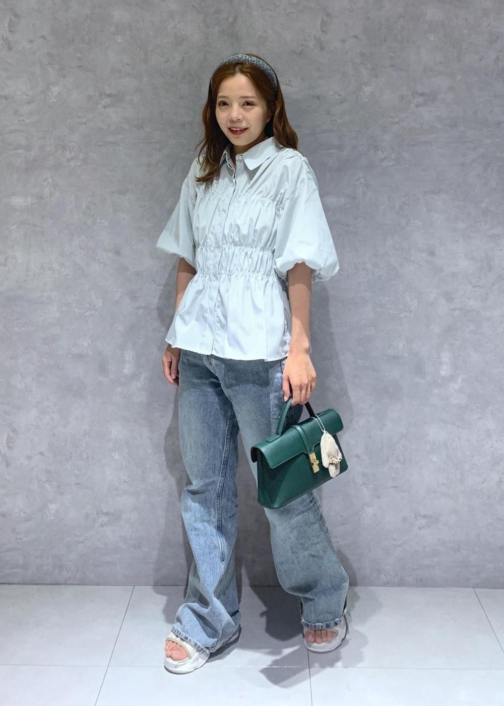 グリーン系のショルダーバッグ、ブルー系のデニムパンツ、グリーン系のシャツ/ブラウスを着用したレディースの夏コーディネートの2枚目の写真