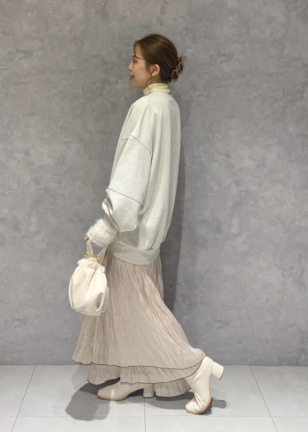 ホワイト系のブーツ、ベージュ系のスカート、ホワイト系のニット/セーターを着用したレディースの秋コーディネートの3枚目の写真
