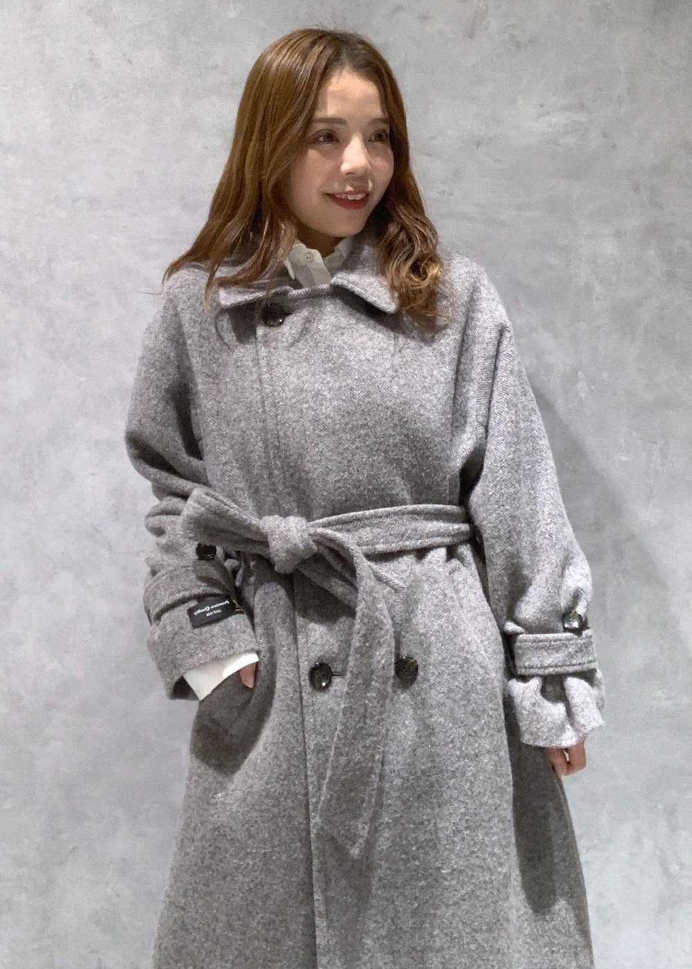 ブラック系のショルダーバッグ、ブラック系のブーツ、グレー系のステンカラーコートを着用したレディースの秋コーディネートの5枚目の写真