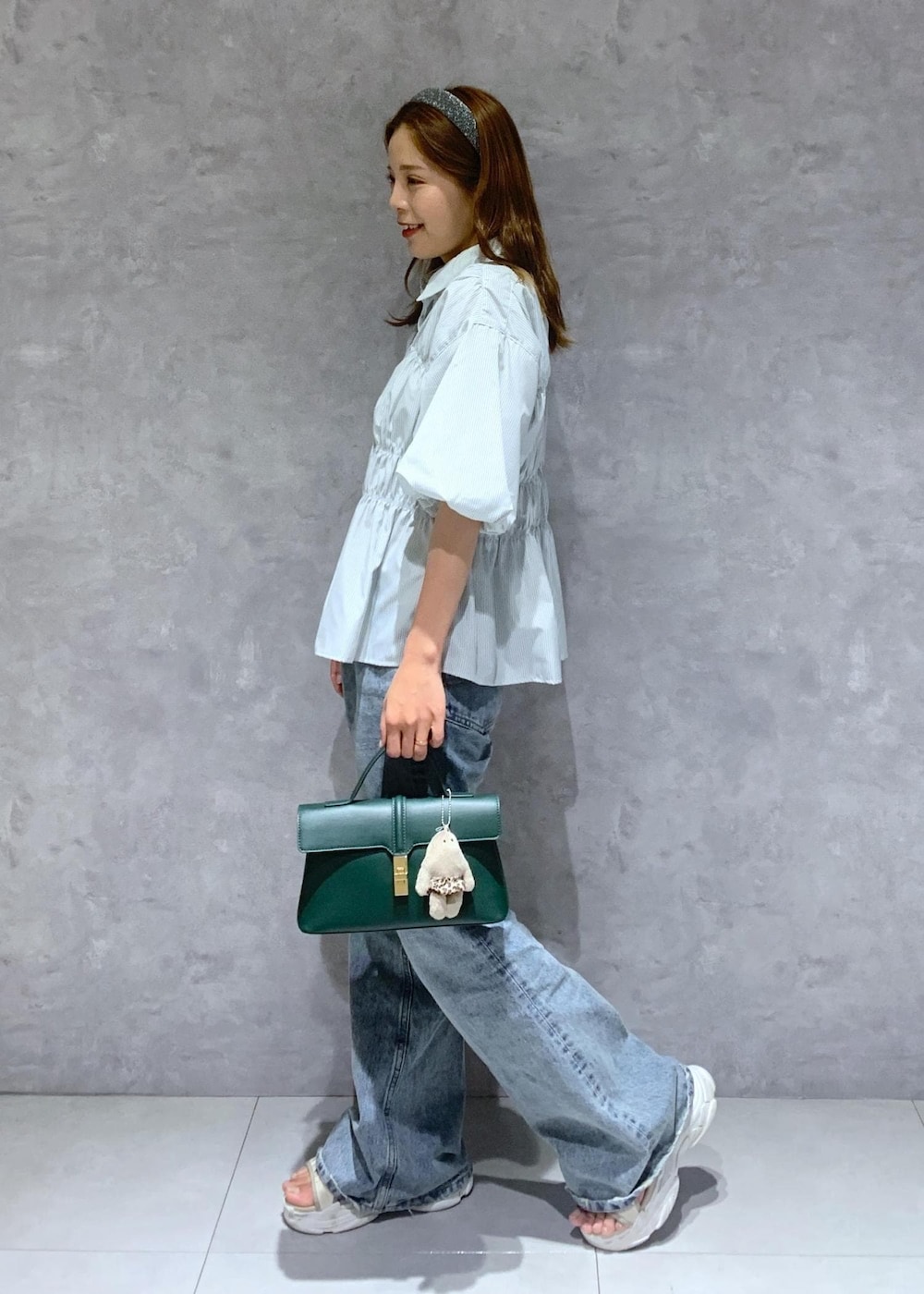 グリーン系のショルダーバッグ、ブルー系のデニムパンツ、グリーン系のシャツ/ブラウスを着用したレディースの夏コーディネートの3枚目の写真