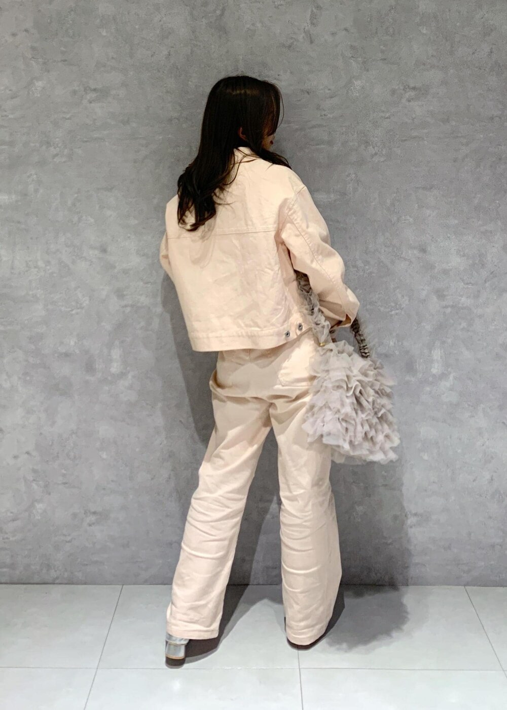 シルバー系のパンプス、ピンク系のデニムパンツ、ホワイト系のニット/セーターを着用したレディースの冬コーディネートの5枚目の写真