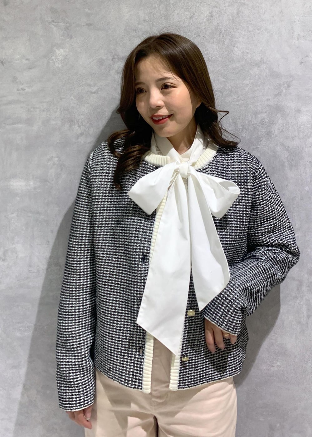 ピンク系のデニムパンツ、ホワイト系のハンドバッグ、ホワイト系のパンプスを着用したレディースの冬コーディネートの7枚目の写真