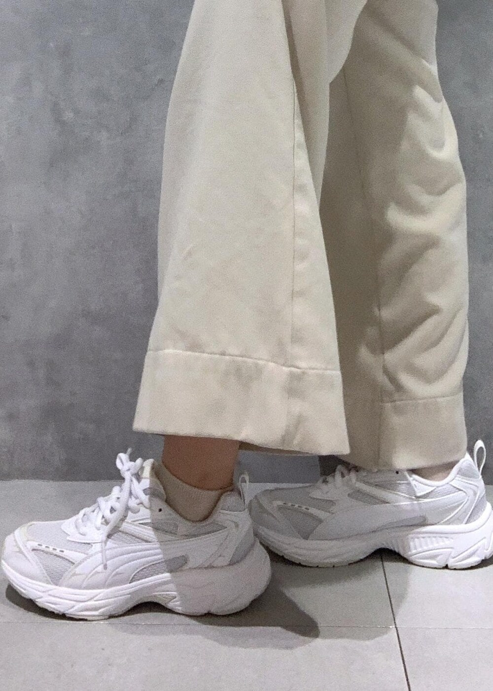 ホワイト系のハンドバッグ、ベージュ系のその他パンツ、グリーン系のニット/セーターを着用したレディースの冬コーディネートの8枚目の写真