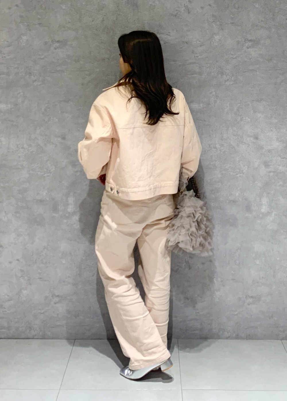 シルバー系のパンプス、ピンク系のデニムパンツ、ホワイト系のニット/セーターを着用したレディースの冬コーディネートの4枚目の写真