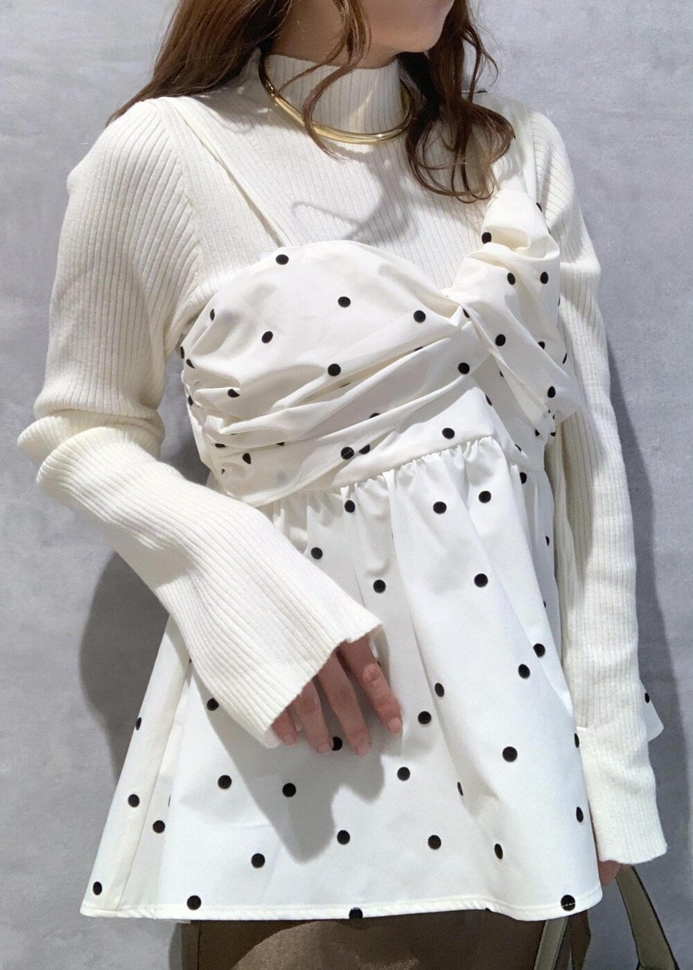 ホワイト系のブーツ、ホワイト系のニット/セーター、ホワイト系のハンドバッグを着用したレディースの冬コーディネートの6枚目の写真