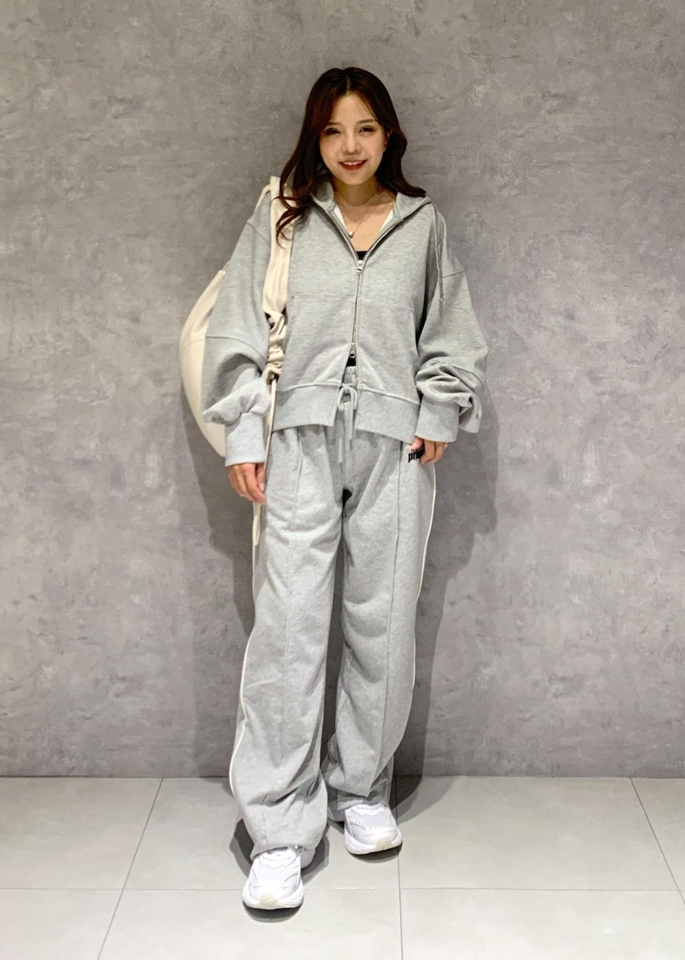 グレー系のその他パンツ、グレー系のパーカー、ホワイト系のショルダーバッグを着用したレディースの冬コーディネートの6枚目の写真