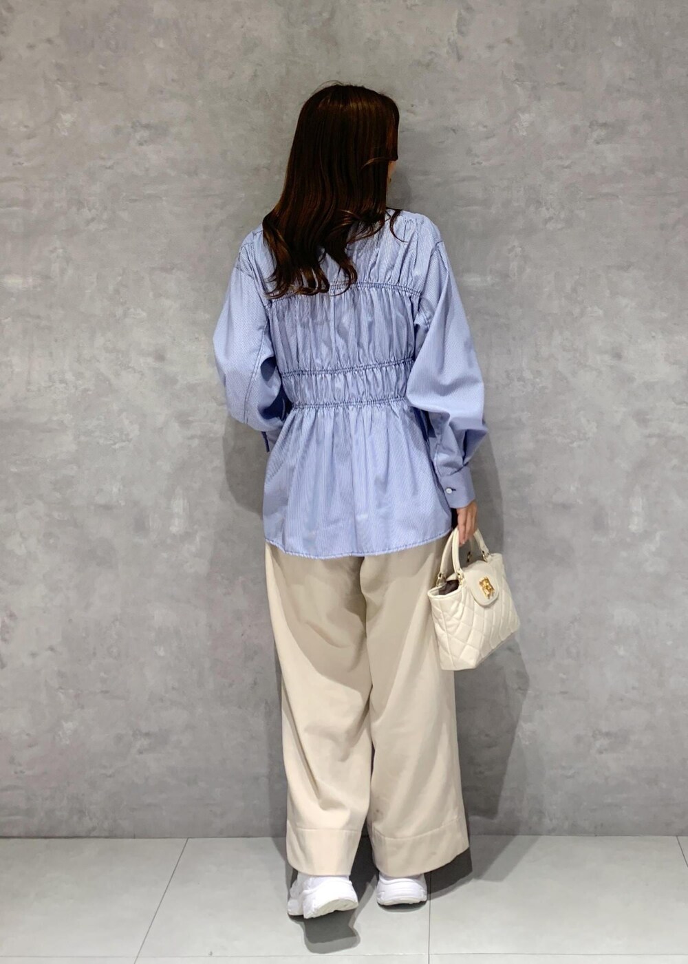 ブルー系のシャツ/ブラウス、ベージュ系のその他パンツ、ホワイト系のショルダーバッグを着用したレディースの冬コーディネートの8枚目の写真