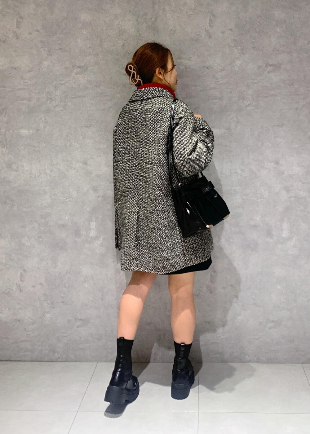 ブラック系のショルダーバッグ、ブラック系のブーツ、レッド系のワンピースを着用したレディースの冬コーディネートの5枚目の写真