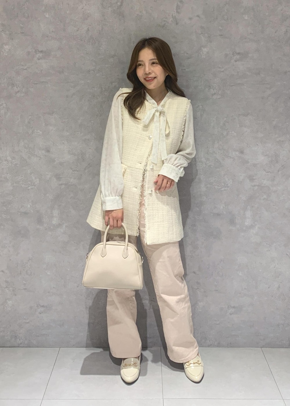 ピンク系のデニムパンツ、ホワイト系のシャツ/ブラウス、ホワイト系のベストを着用したレディースの冬コーディネートの2枚目の写真