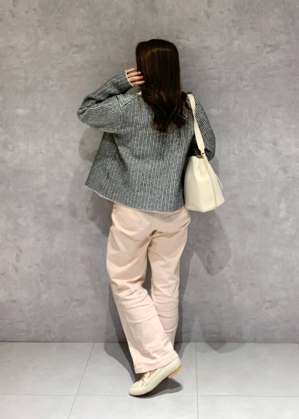 ピンク系のデニムパンツ、ホワイト系のハンドバッグ、ホワイト系のパンプスを着用したレディースの冬コーディネートの5枚目の写真