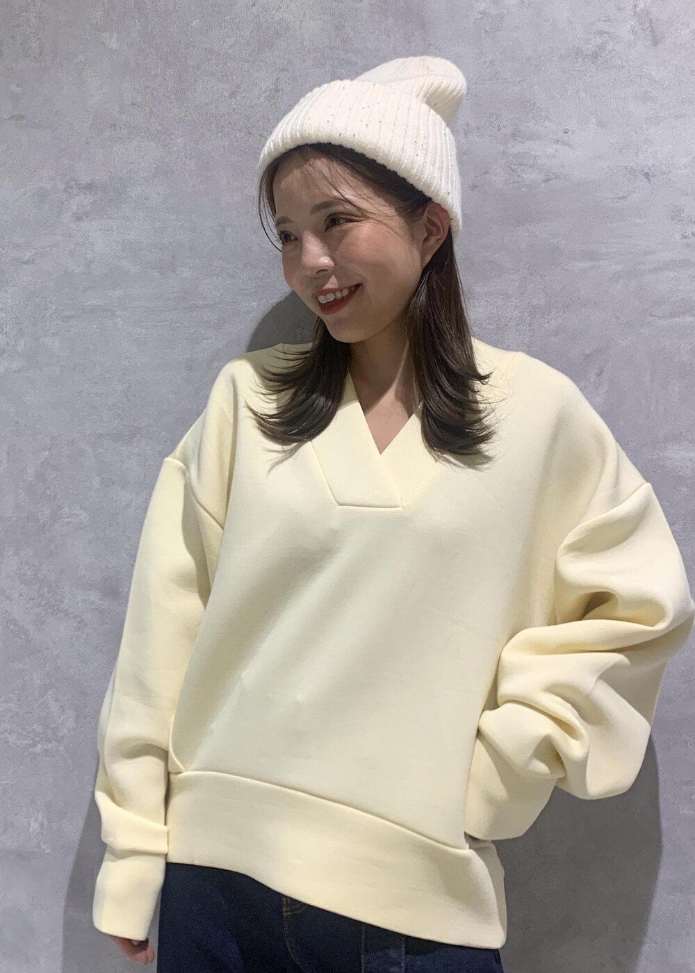 ブルー系のデニムパンツ、ホワイト系のブーツ、ホワイト系のショルダーバッグを着用したレディースの秋コーディネートの5枚目の写真