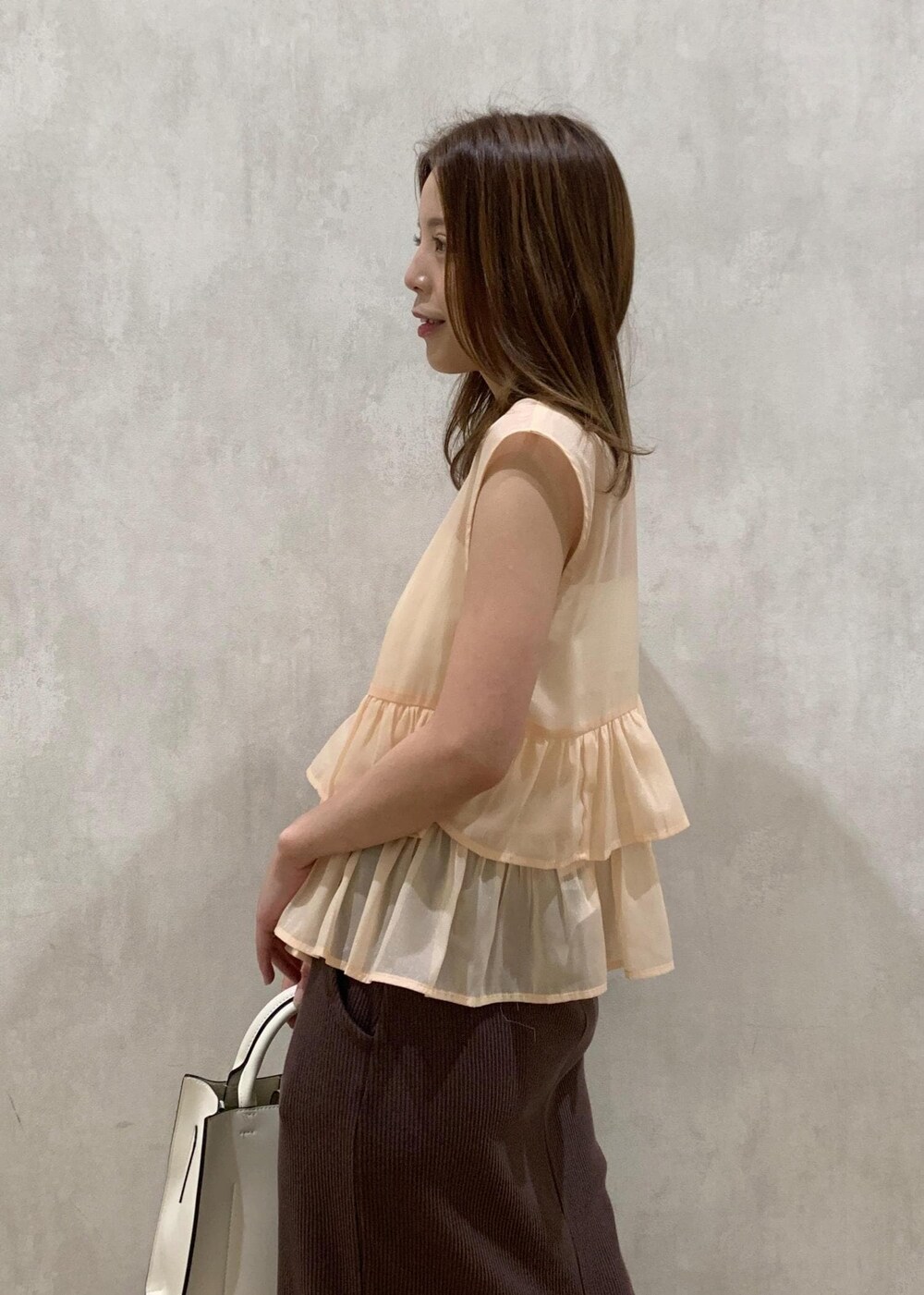 ベージュ系のサンダル、ホワイト系のハンドバッグ、ベージュ系のシャツ/ブラウスを着用したレディースの夏コーディネートの5枚目の写真