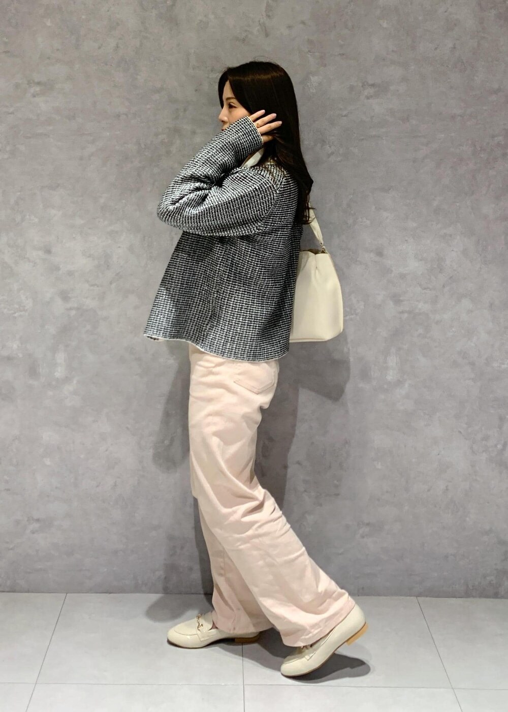 ピンク系のデニムパンツ、ホワイト系のハンドバッグ、ホワイト系のパンプスを着用したレディースの冬コーディネートの4枚目の写真