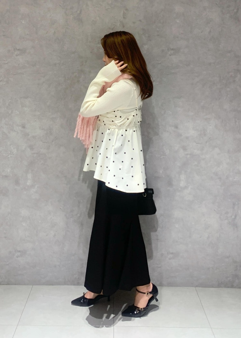 ブラック系のショルダーバッグ、ホワイト系のニット/セーター、ブラック系のスカートを着用したレディースの冬コーディネートの4枚目の写真