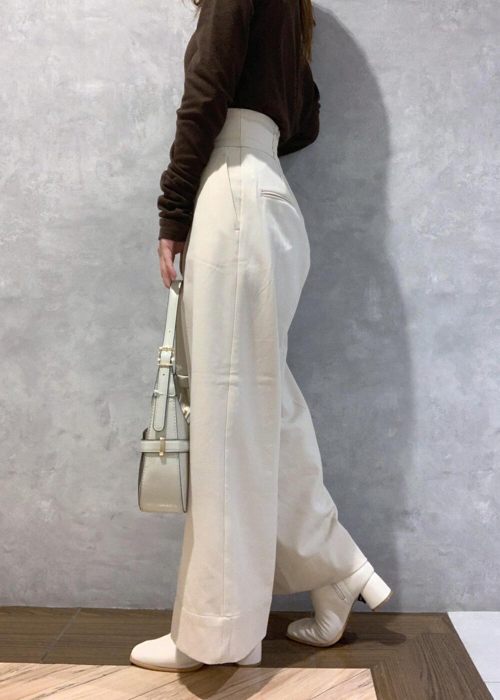 ホワイト系のブーツ、ホワイト系のハンドバッグ、ベージュ系のその他パンツを着用したレディースの秋コーディネートの9枚目の写真