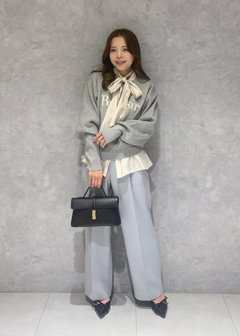 ブラック系のショルダーバッグ、ホワイト系のシャツ/ブラウス、ブルー系のスラックスを着用したレディースの冬コーディネートの2枚目の写真