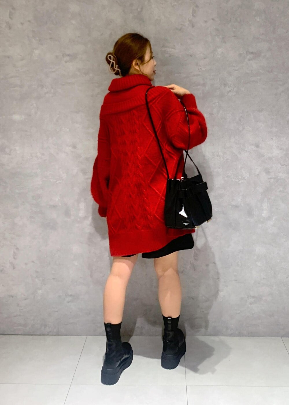 ブラック系のショルダーバッグ、ブラック系のブーツ、レッド系のワンピースを着用したレディースの冬コーディネートの9枚目の写真