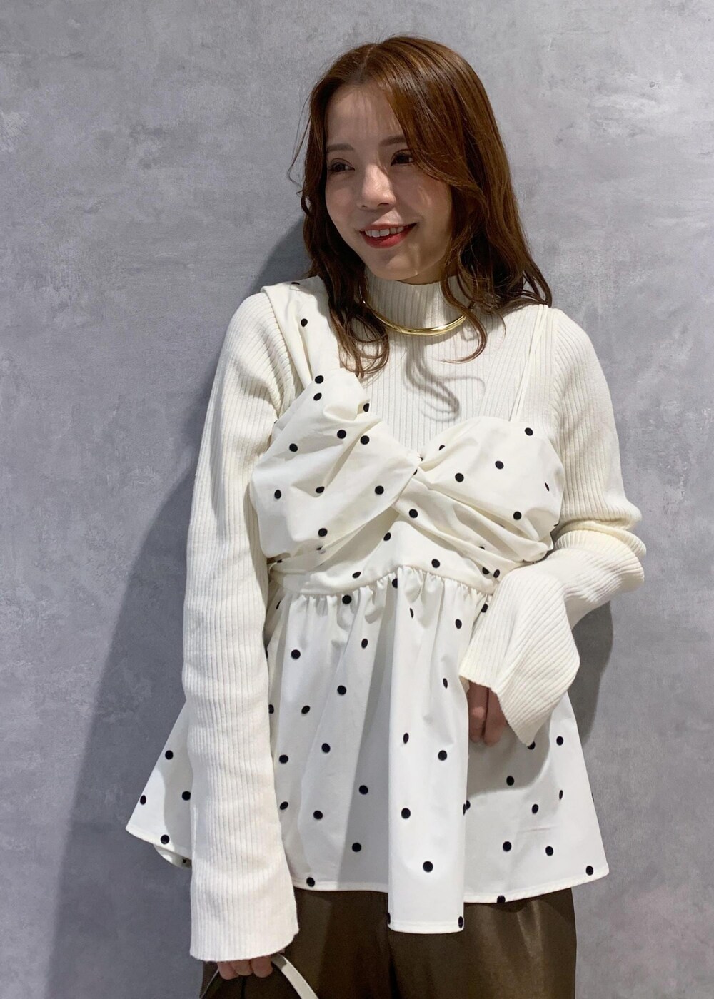 ホワイト系のブーツ、ホワイト系のニット/セーター、ホワイト系のハンドバッグを着用したレディースの冬コーディネートの5枚目の写真