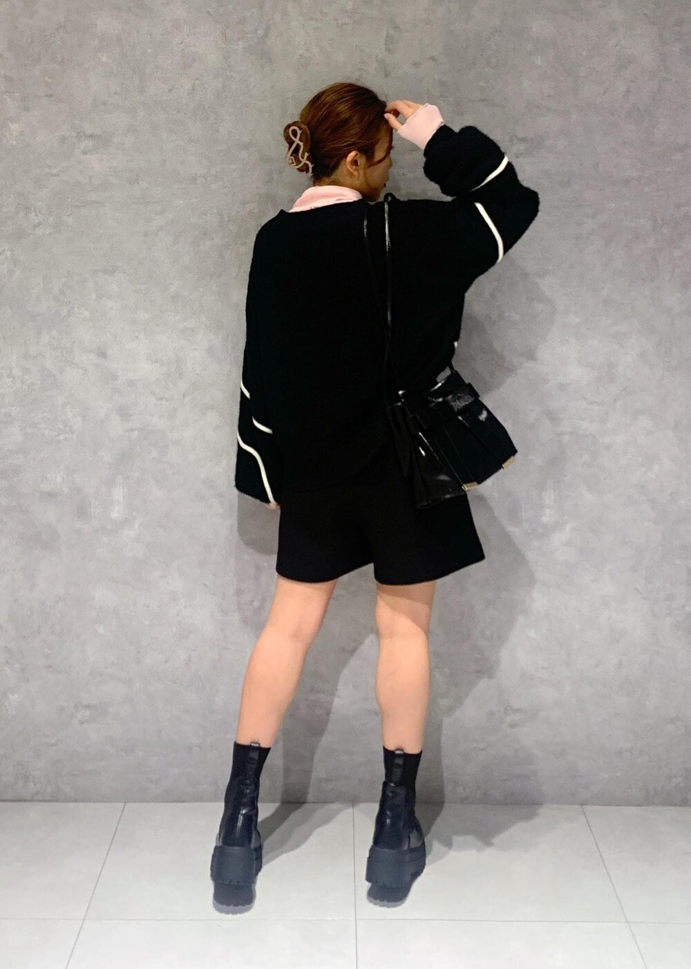 ブラック系のショルダーバッグ、ブラック系のブーツ、ブラック系のニット/セーターを着用したレディースの冬コーディネートの6枚目の写真