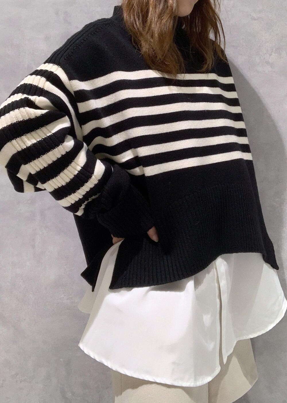 ブラック系のブーツ、ホワイト系のシャツ/ブラウス、ブラック系のニット/セーターを着用したレディースの秋コーディネートの8枚目の写真