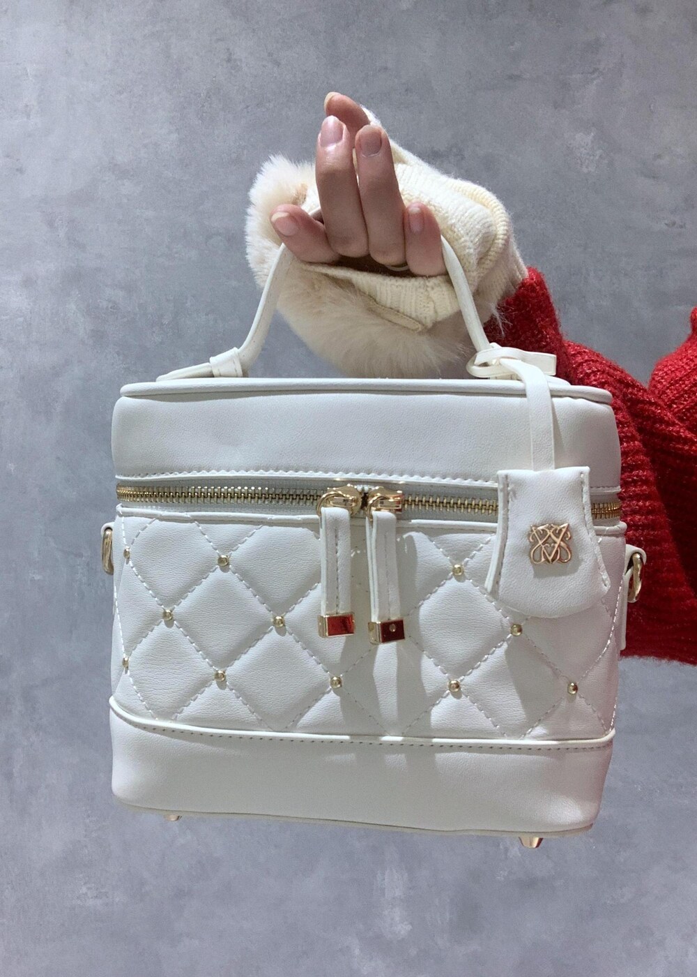 ホワイト系のブーツ、ホワイト系のハンドバッグ、レッド系のワンピースを着用したレディースの冬コーディネートの8枚目の写真