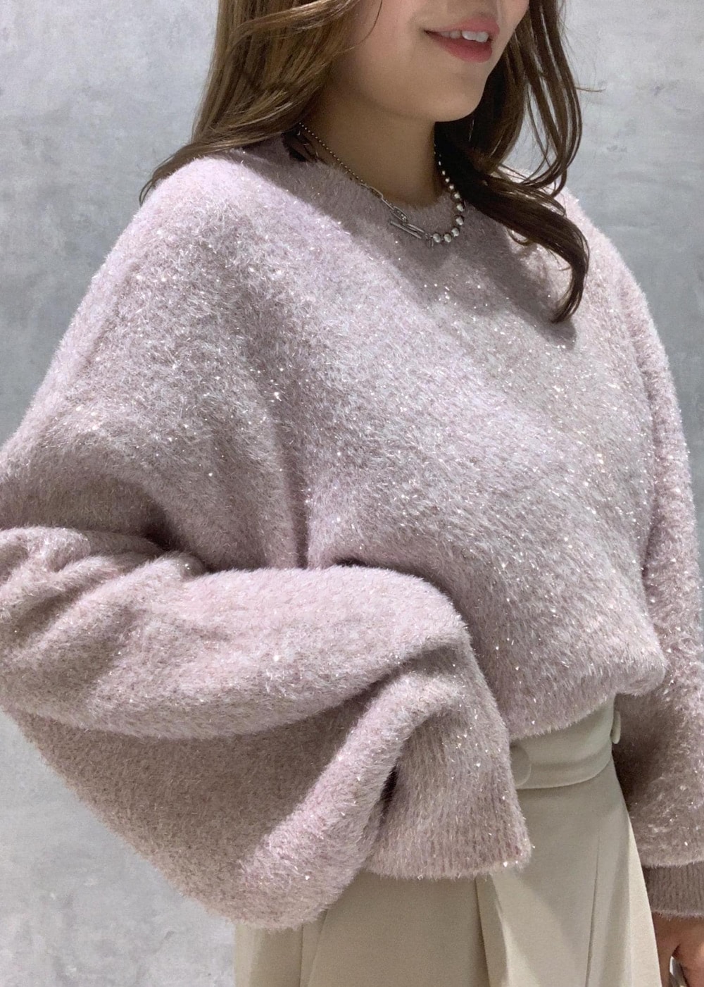 ピンク系のニット/セーター、ベージュ系のその他パンツ、ホワイト系のショルダーバッグを着用したレディースの冬コーディネートの8枚目の写真