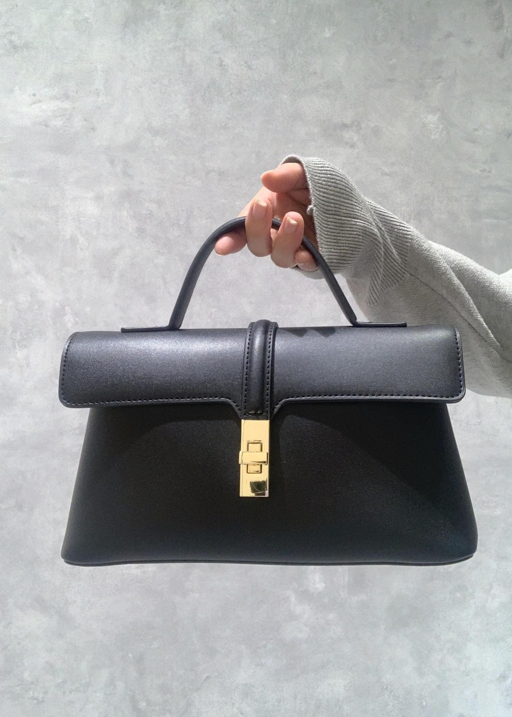 ブラック系のショルダーバッグ、ホワイト系のニット/セーター、ブラック系のスカートを着用したレディースの冬コーディネートの10枚目の写真