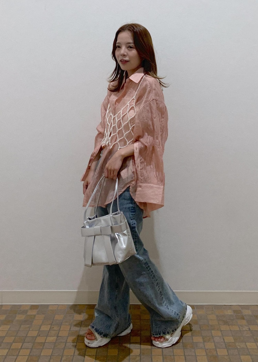 ピンク系のシャツ/ブラウス、ブルー系のデニムパンツ、シルバー系のショルダーバッグを着用したレディースの夏コーディネートの2枚目の写真