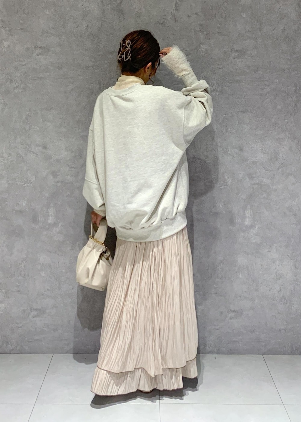 ホワイト系のブーツ、ベージュ系のスカート、ホワイト系のニット/セーターを着用したレディースの秋コーディネートの5枚目の写真