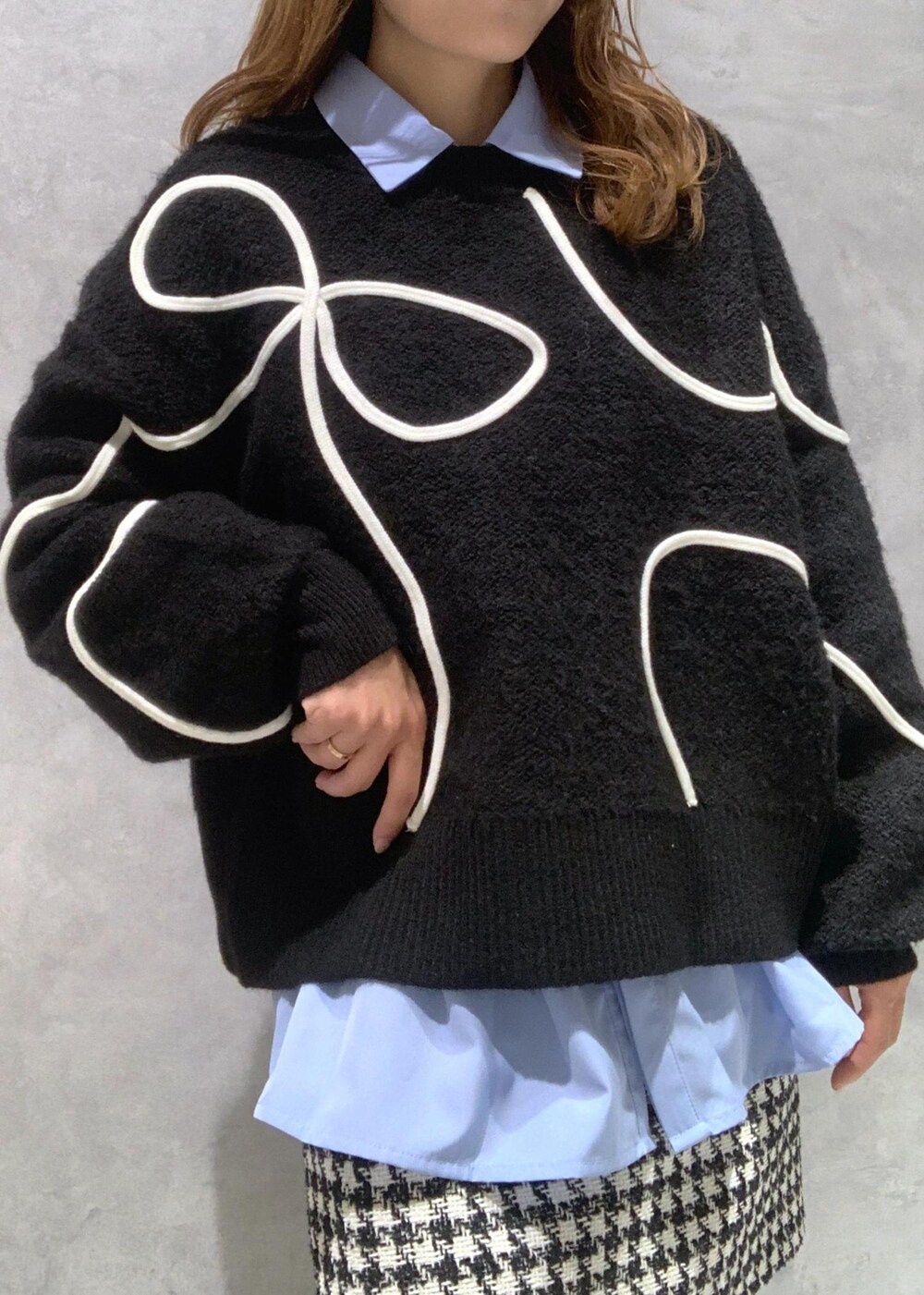 ブラック系のショルダーバッグ、ブラック系のブーツ、ブラック系のニット/セーターを着用したレディースの冬コーディネートの8枚目の写真