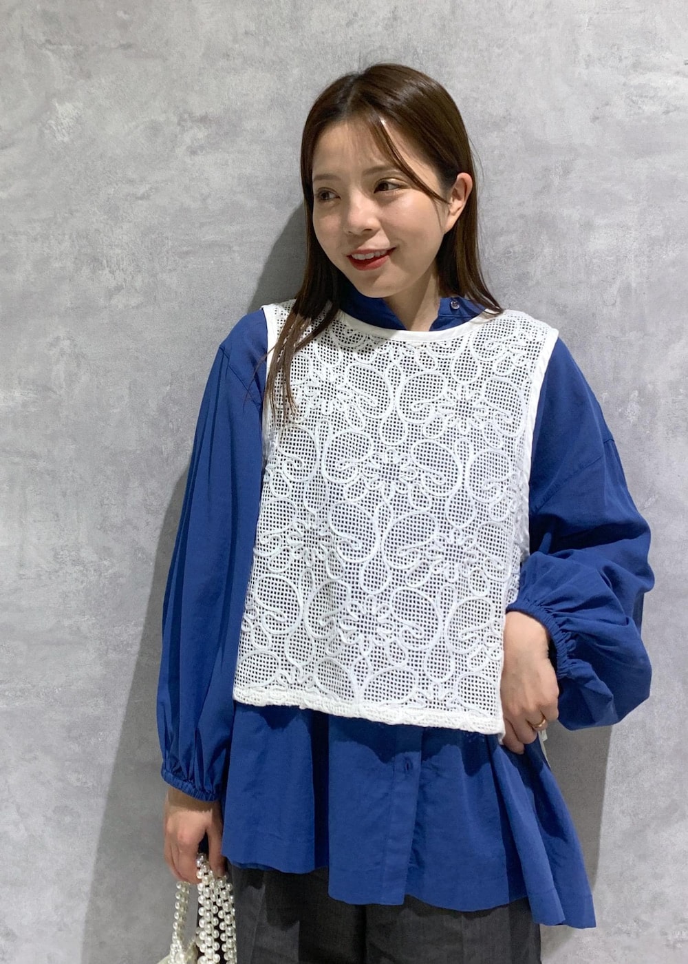 ブルー系のシャツ/ブラウス、グレー系のローファー、ホワイト系のハンドバッグを着用したレディースの春コーディネートの6枚目の写真