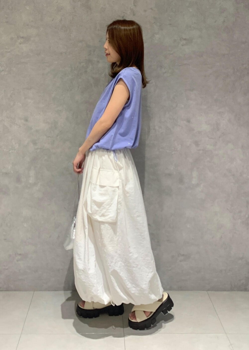 ホワイト系のサンダル、ホワイト系のワンピース、シルバー系のショルダーバッグを着用したレディースの夏コーディネートの3枚目の写真