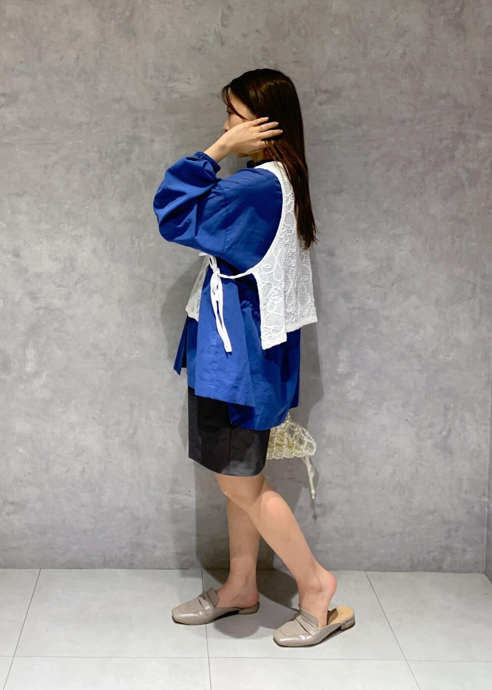 ブルー系のシャツ/ブラウス、グレー系のローファー、ホワイト系のハンドバッグを着用したレディースの春コーディネートの4枚目の写真