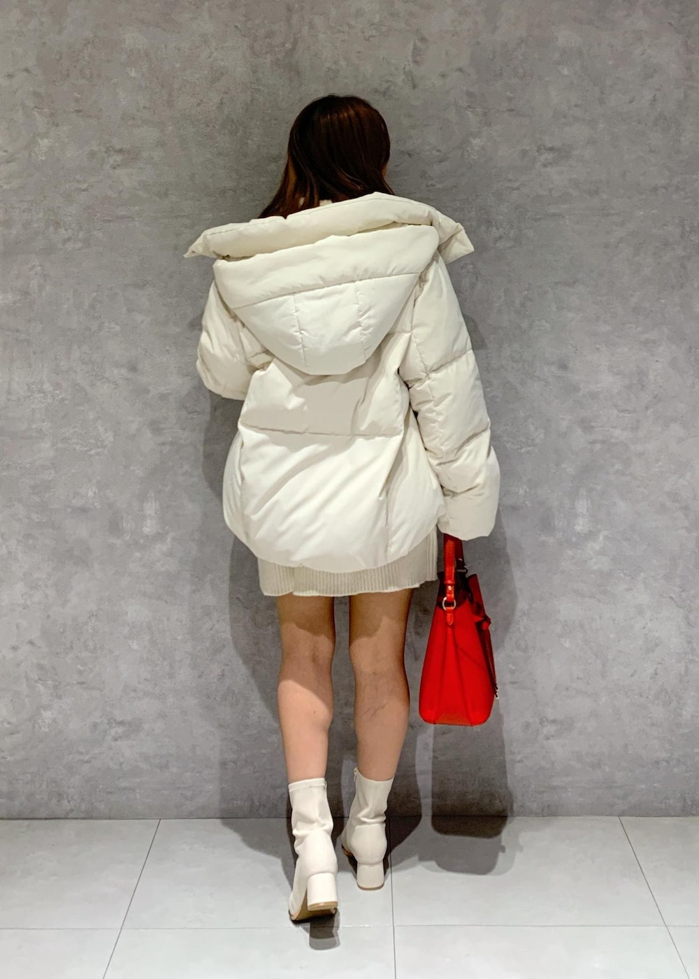 ホワイト系のブーツ、ホワイト系のワンピース、ホワイト系のダウンジャケット/コートを着用したレディースの秋コーディネートの4枚目の写真
