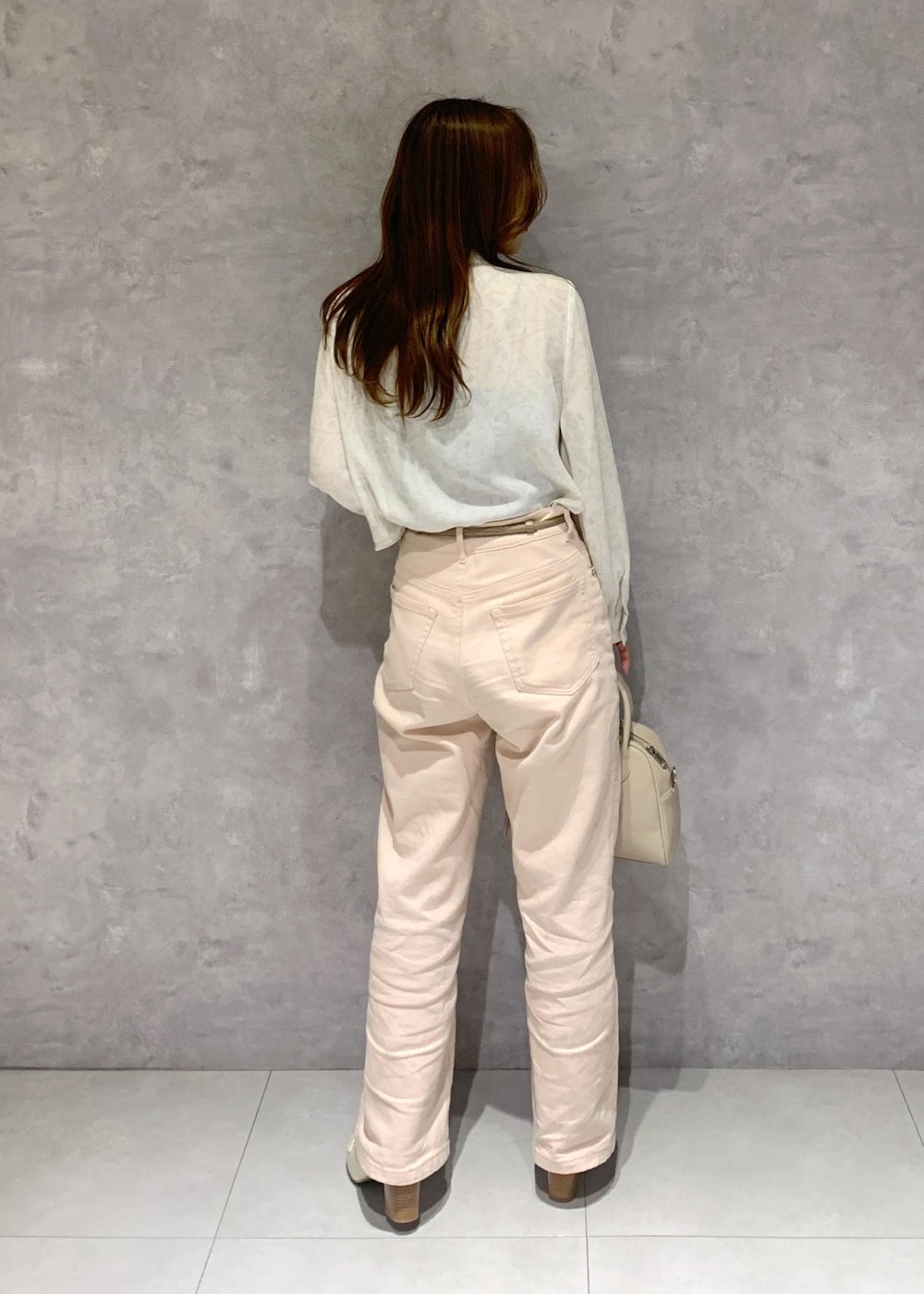 ピンク系のデニムパンツ、ホワイト系のシャツ/ブラウス、ホワイト系のローファーを着用したレディースの冬コーディネートの5枚目の写真