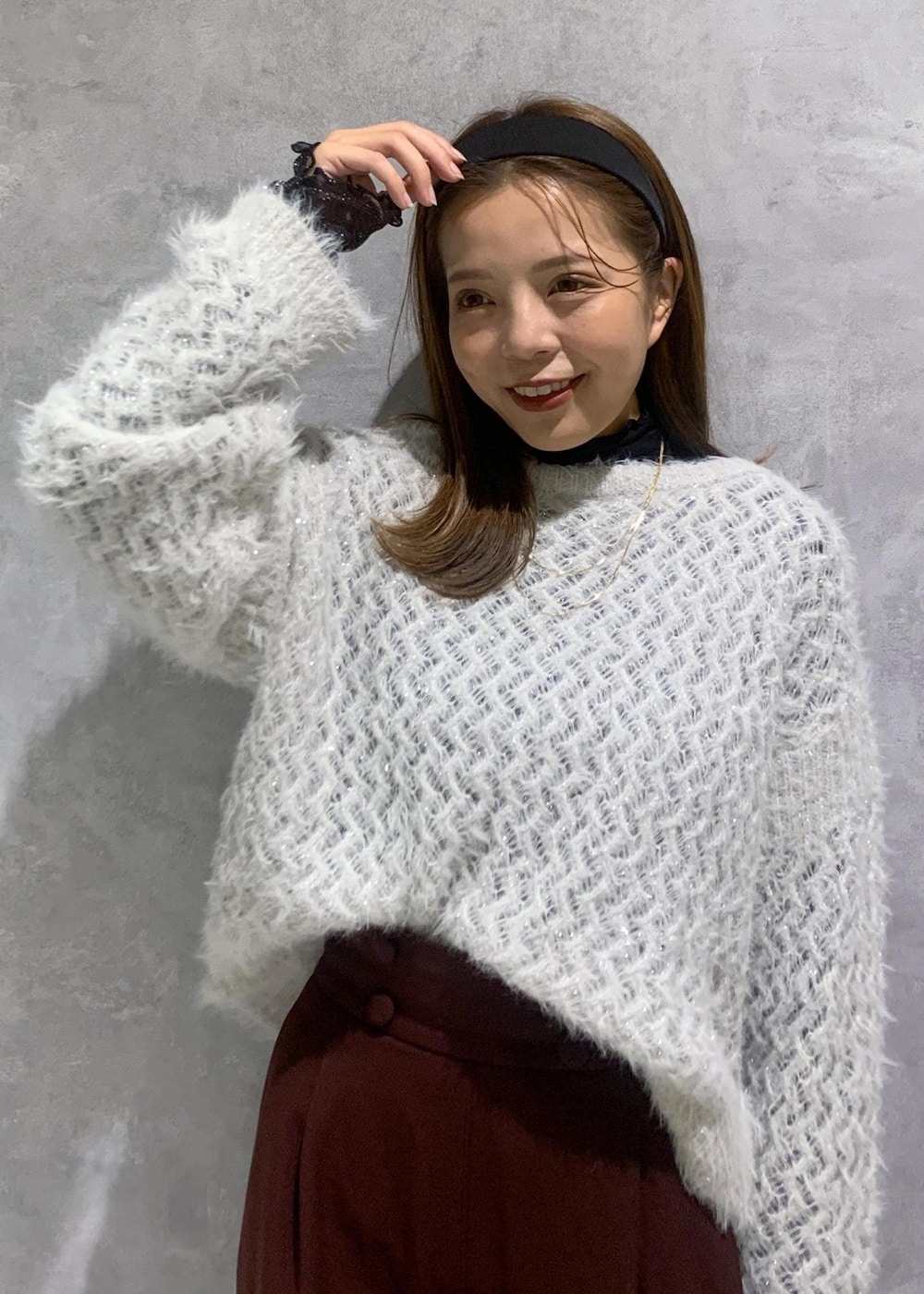 ブラック系のハンドバッグ、グレー系のニット/セーター、ブラック系のTシャツ/カットソーを着用したレディースの秋コーディネートの6枚目の写真
