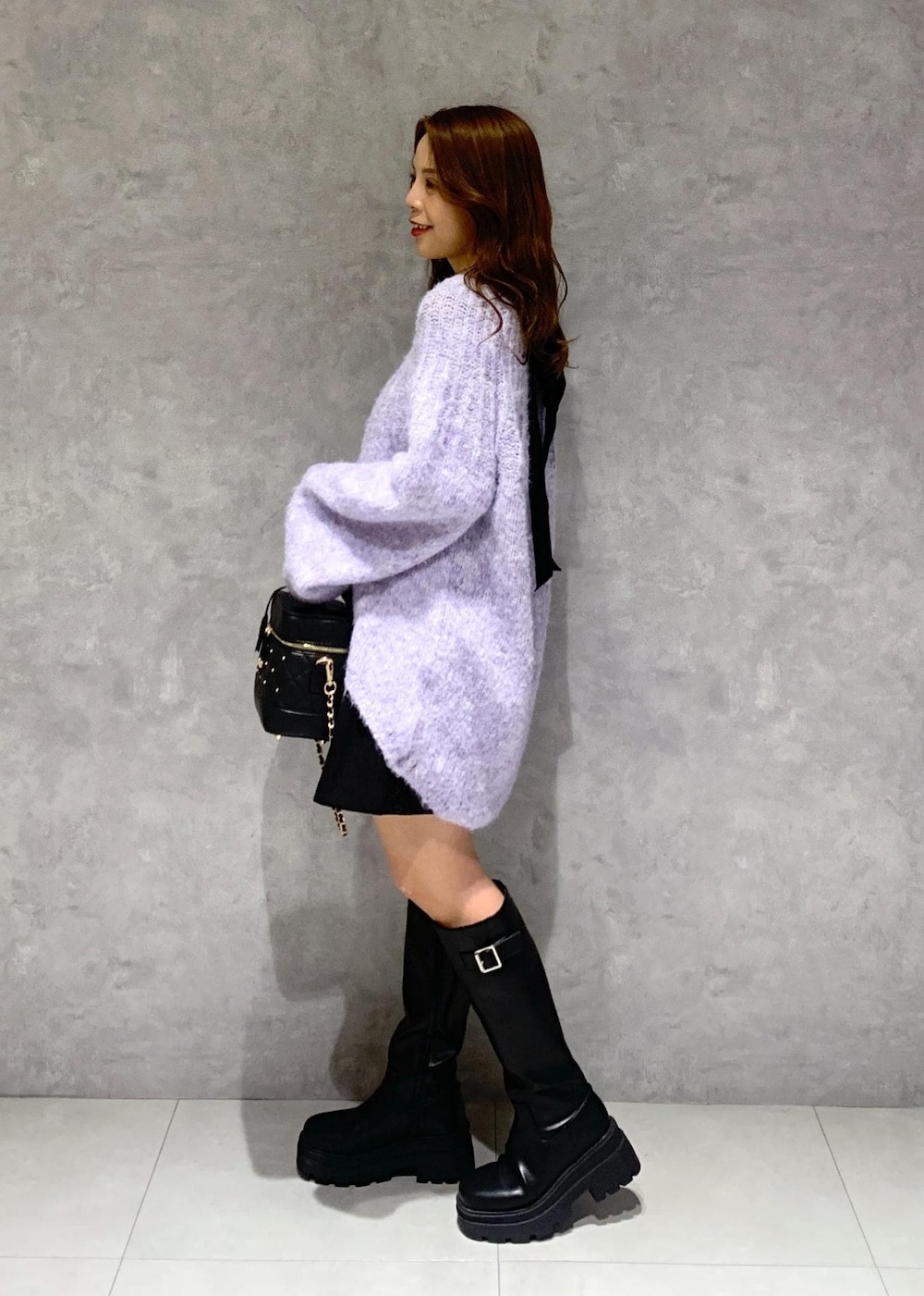 ブラック系のブーツ、パープル系のニット/セーター、ブラック系のその他パンツを着用したレディースの冬コーディネートの5枚目の写真
