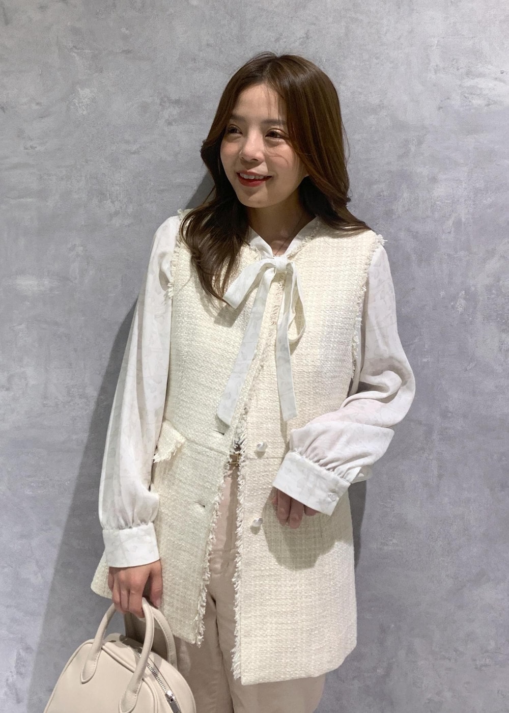 ピンク系のデニムパンツ、ホワイト系のシャツ/ブラウス、ホワイト系のベストを着用したレディースの冬コーディネートの6枚目の写真