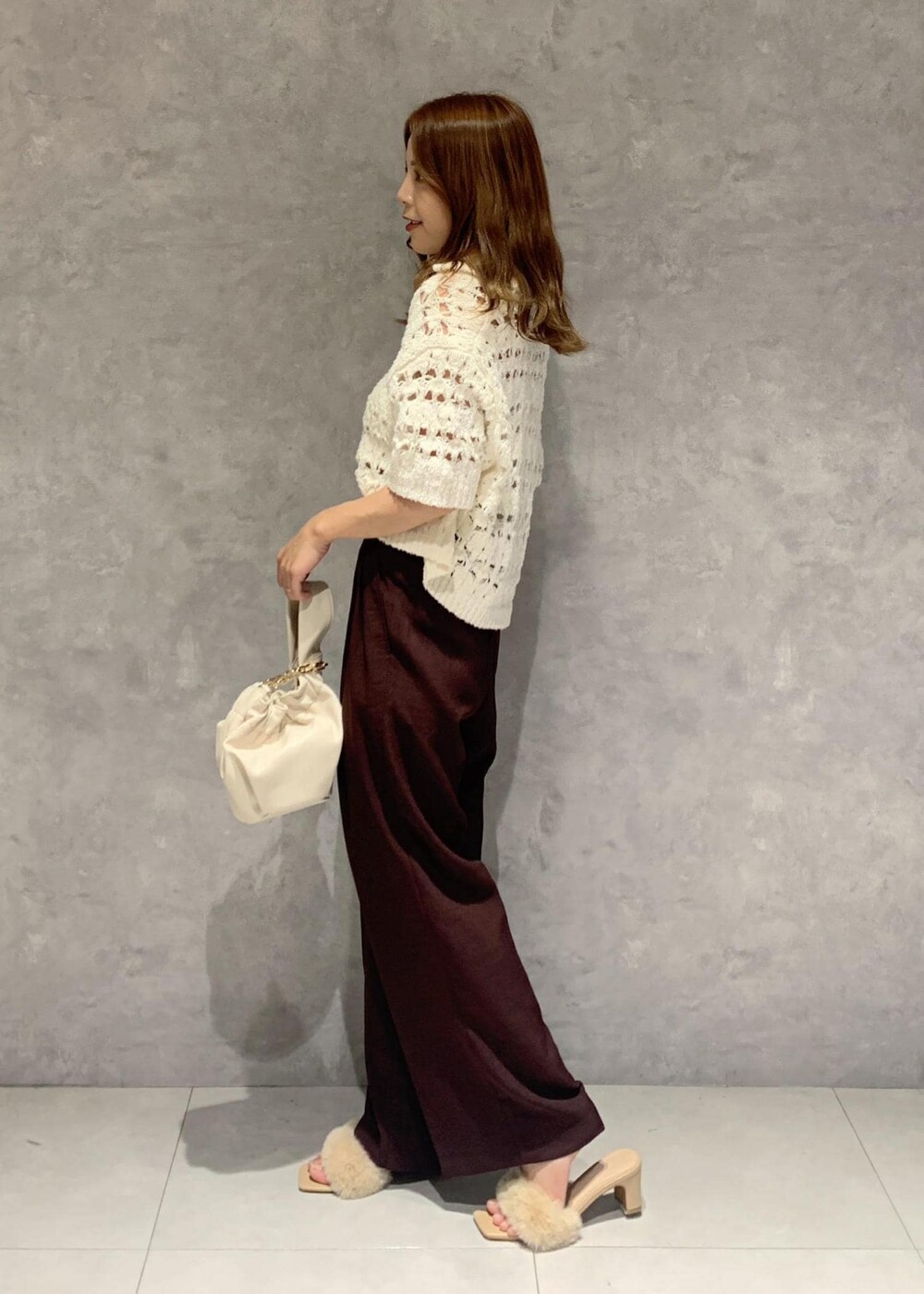 ホワイト系のその他トップス、ブラウン系のスラックス、ホワイト系のハンドバッグを着用したレディースの夏コーディネートの3枚目の写真