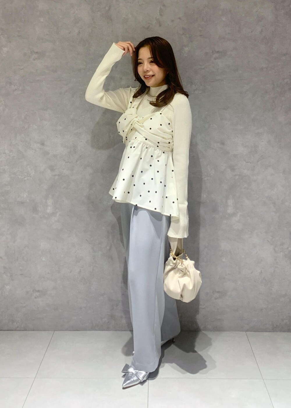 シルバー系のパンプス、ホワイト系のハンドバッグ、ホワイト系のニット/セーターを着用したレディースの冬コーディネートの3枚目の写真