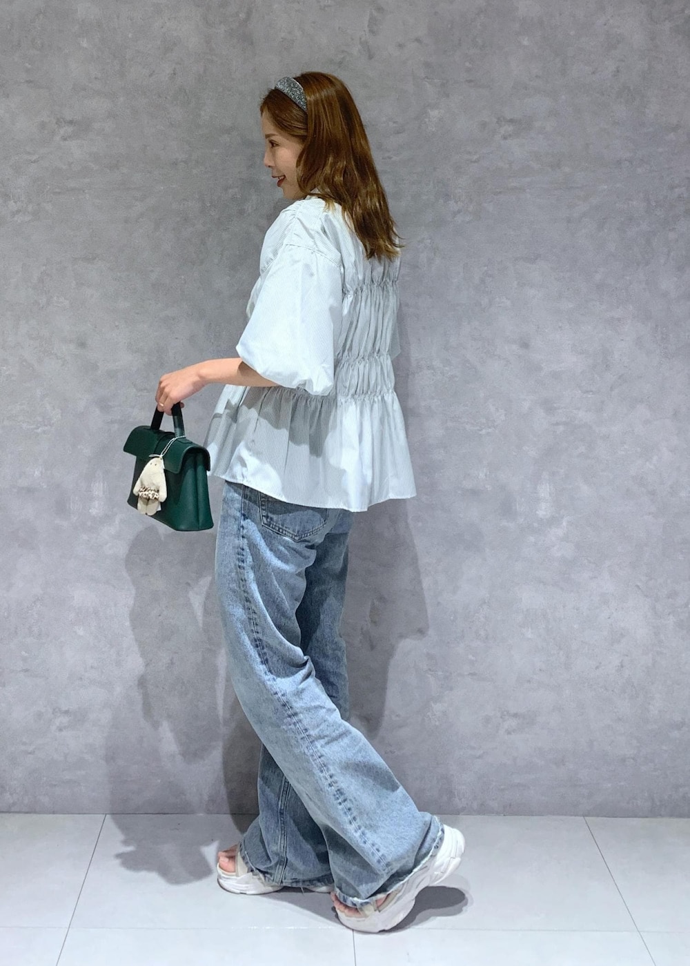 グリーン系のショルダーバッグ、ブルー系のデニムパンツ、グリーン系のシャツ/ブラウスを着用したレディースの夏コーディネートの4枚目の写真
