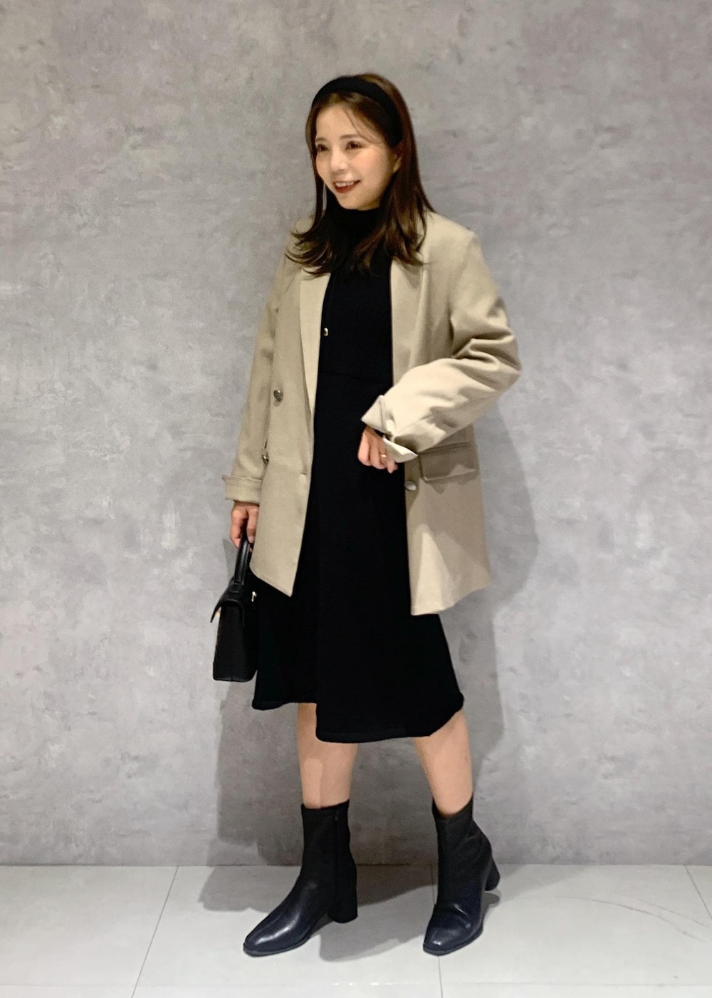 その他のショルダーバッグ、ブラック系のブーツ、ベージュ系のテーラードジャケットを着用したレディースの秋コーディネートの2枚目の写真