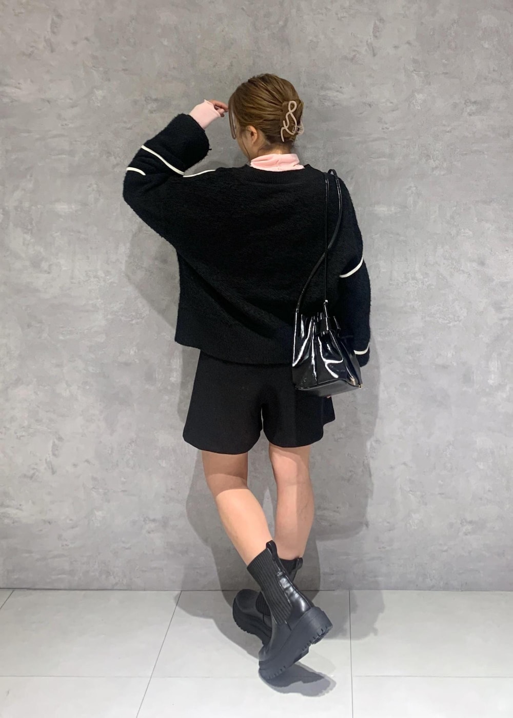 ブラック系のショルダーバッグ、ブラック系のブーツ、ブラック系のニット/セーターを着用したレディースの冬コーディネートの5枚目の写真