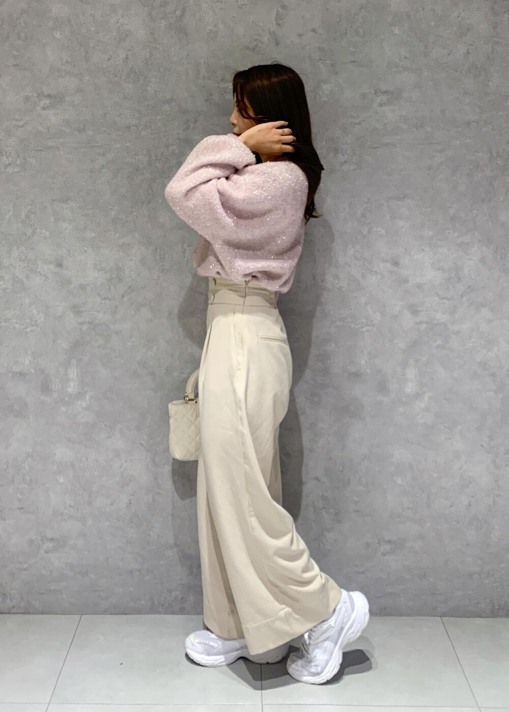 ピンク系のニット/セーター、ベージュ系のその他パンツ、ホワイト系のショルダーバッグを着用したレディースの冬コーディネートの4枚目の写真