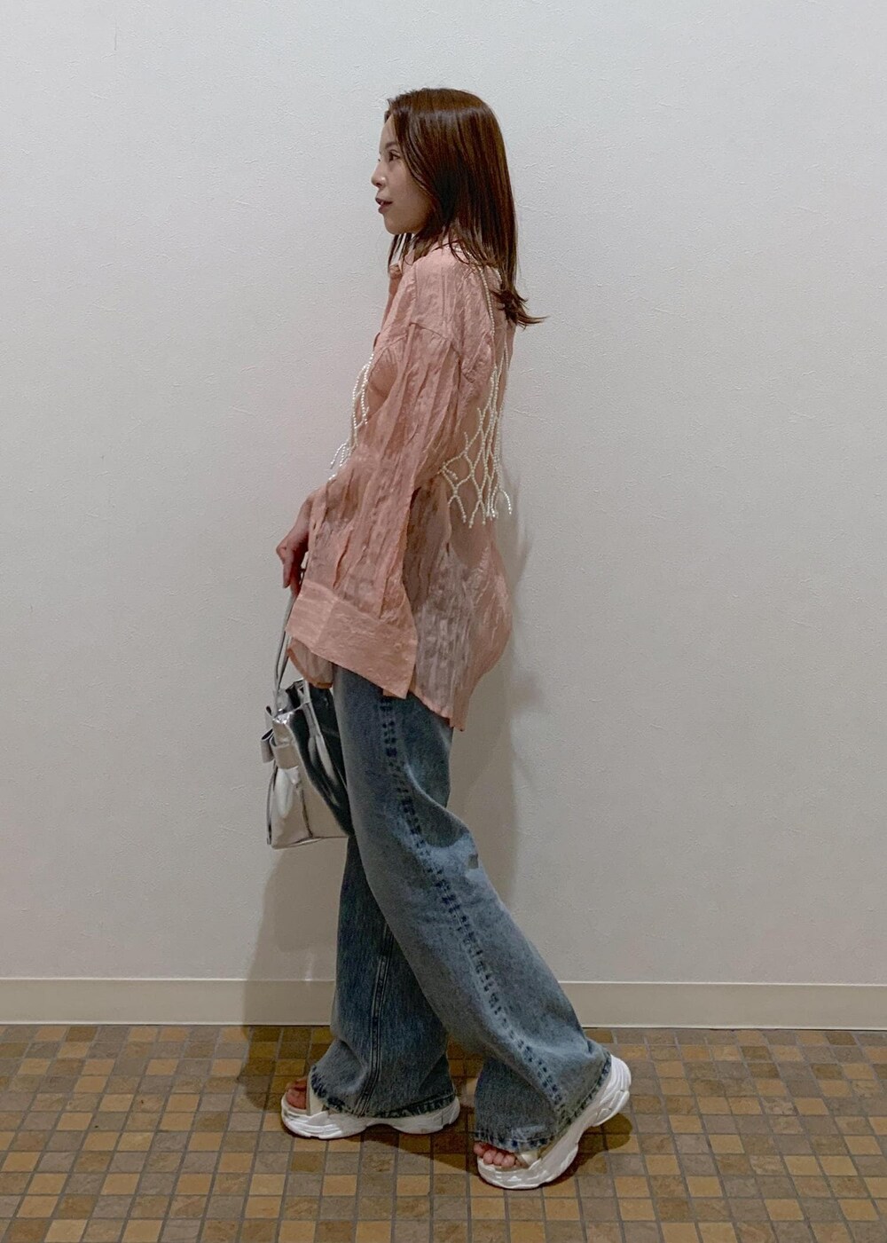 ピンク系のシャツ/ブラウス、ブルー系のデニムパンツ、シルバー系のショルダーバッグを着用したレディースの夏コーディネートの3枚目の写真