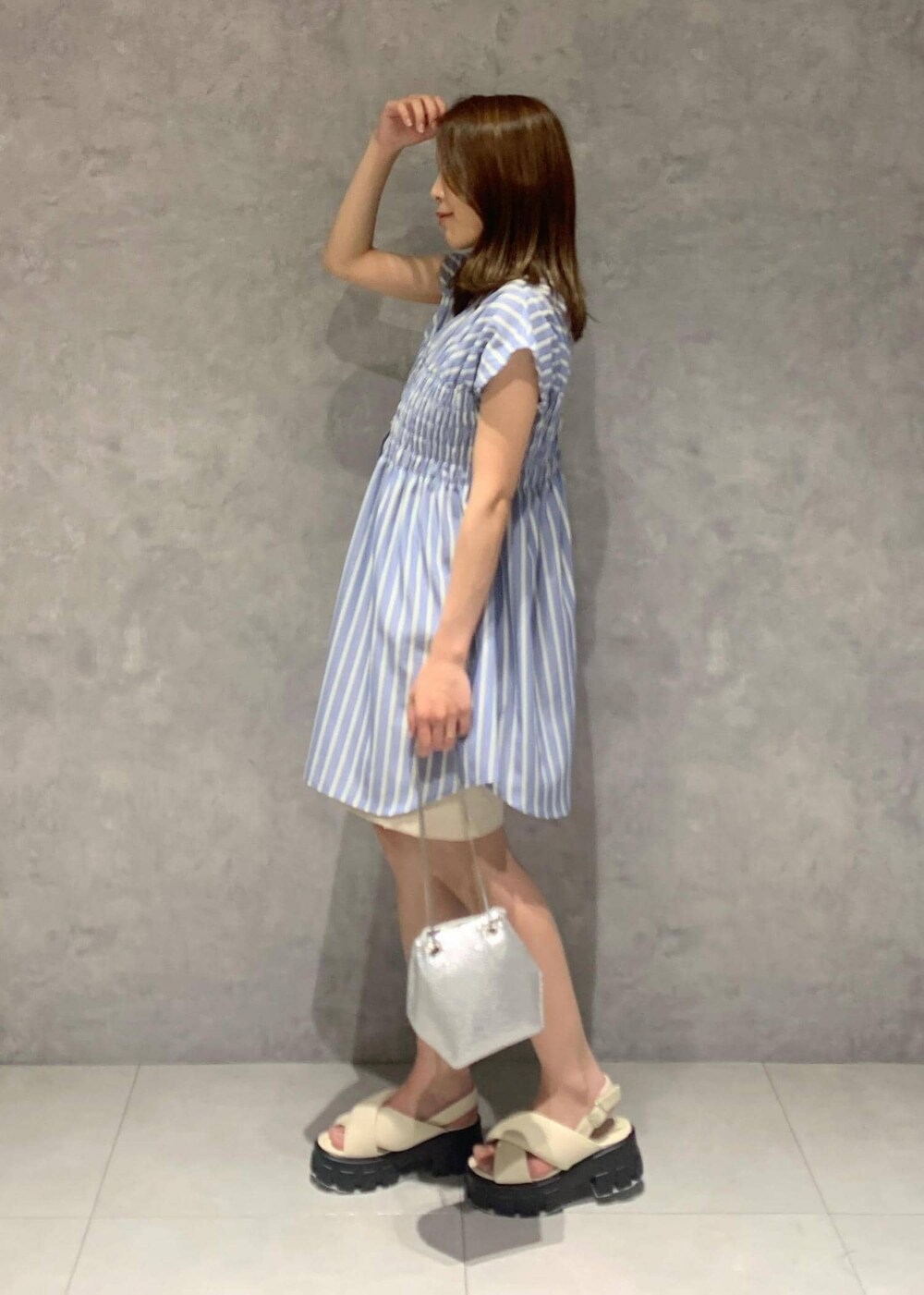 ホワイト系のサンダル、シルバー系のショルダーバッグ、ブルー系のシャツ/ブラウスを着用したレディースの夏コーディネートの3枚目の写真