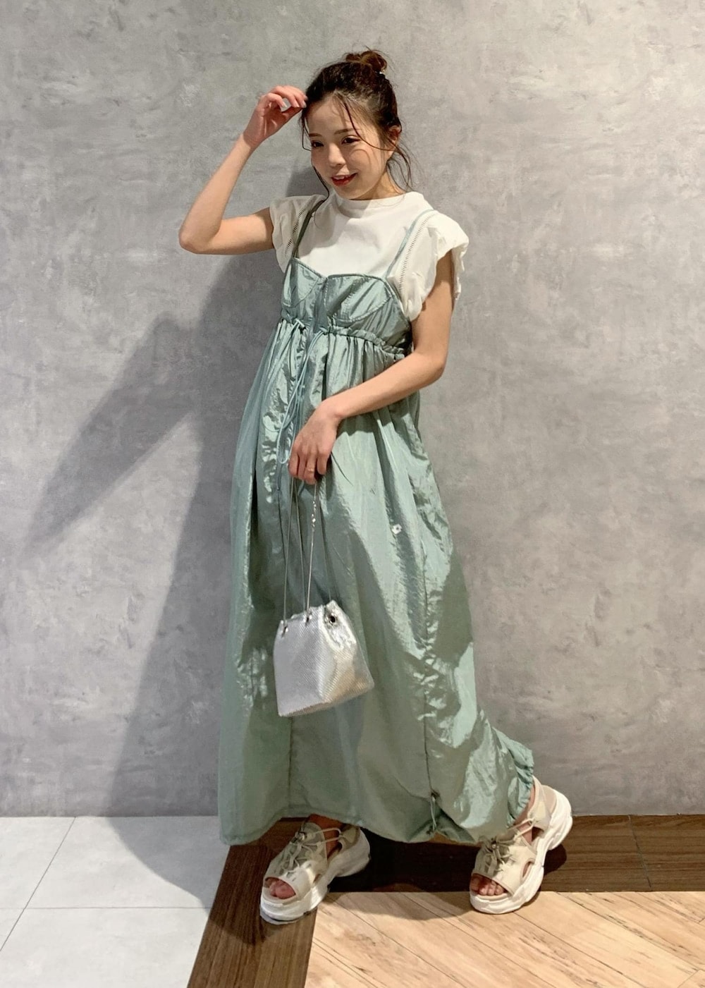 ベージュ系のサンダル、グリーン系のワンピース、ホワイト系のTシャツ/カットソーを着用したレディースの夏コーディネートの2枚目の写真