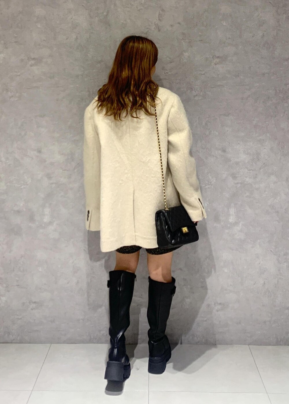 ブラック系のショルダーバッグ、ブラック系のブーツ、ブラック系のニット/セーターを着用したレディースの秋コーディネートの4枚目の写真