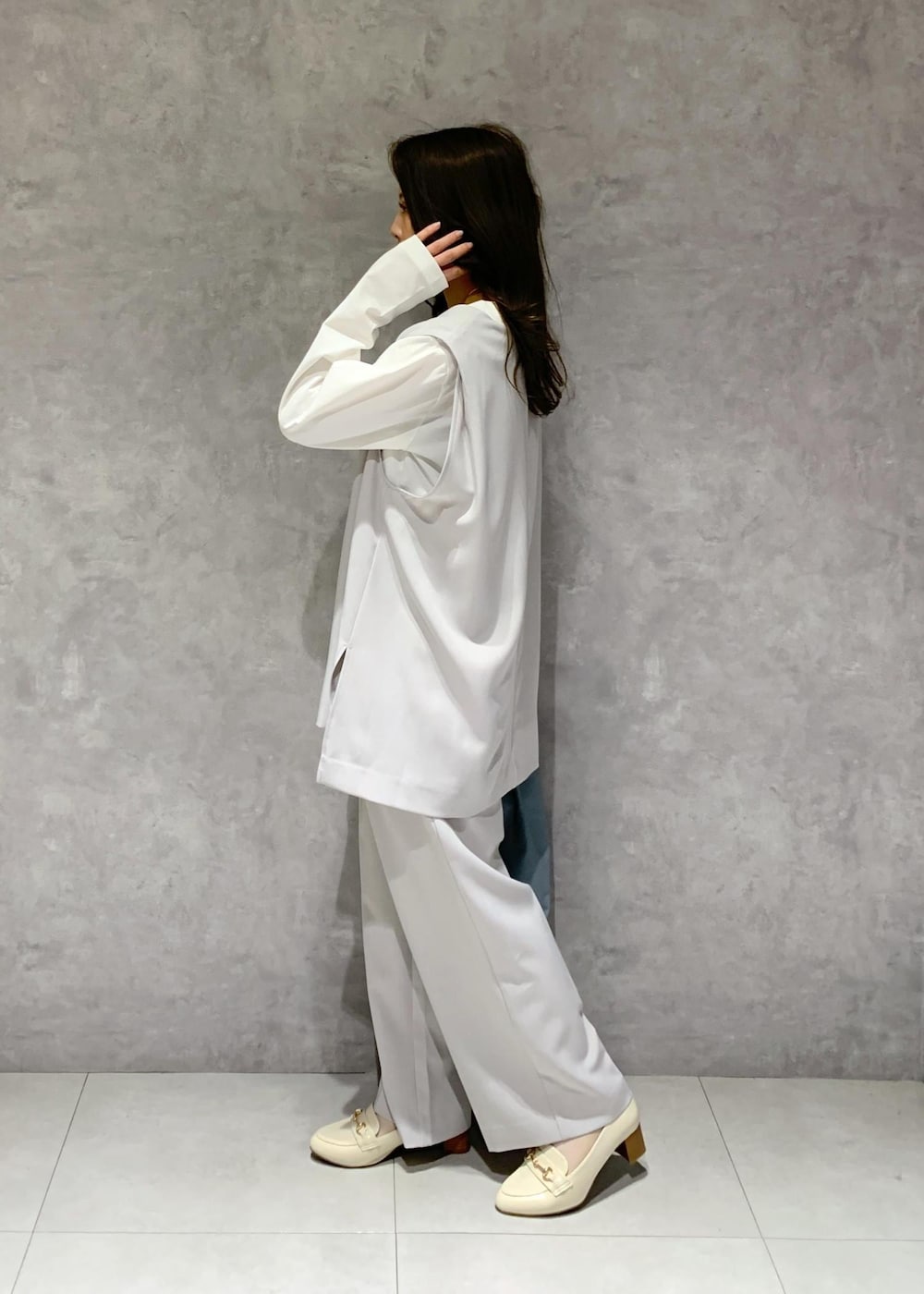 ブルー系のトートバッグ、ホワイト系のTシャツ/カットソー、ホワイト系のローファーを着用したレディースの冬コーディネートの4枚目の写真